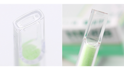 Two test tubes with green liquid against a blurred background